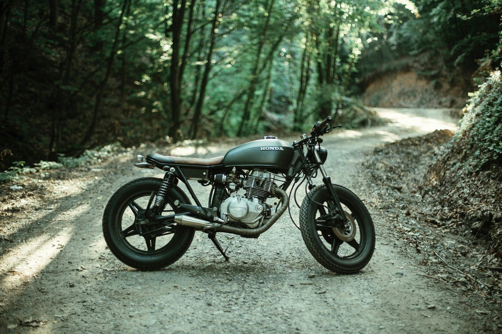 Uma bela foto de uma moto da honda com uma floresta de fundo